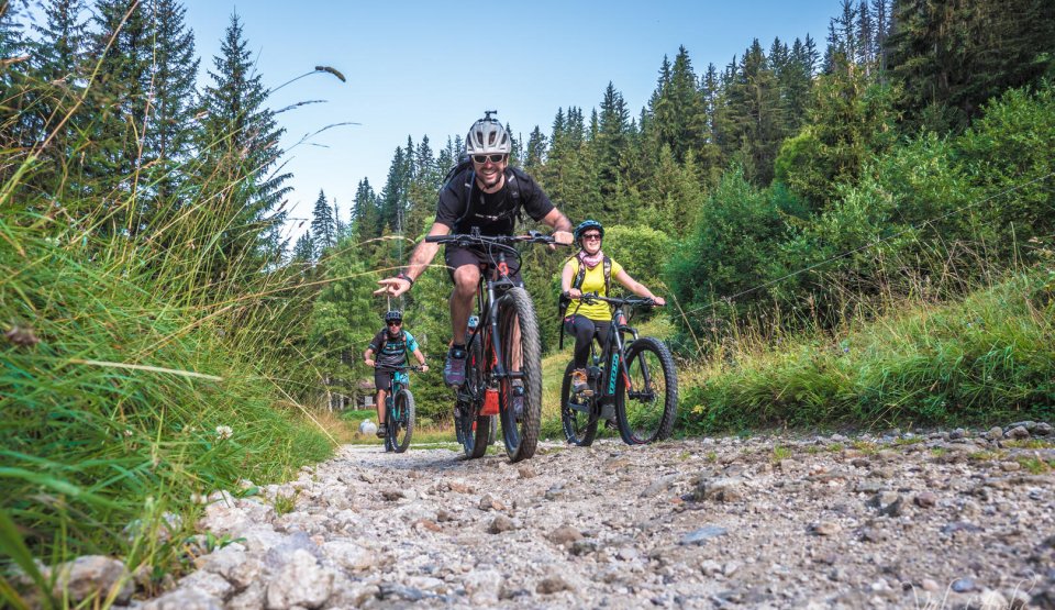 3 personnes à vélo dans un chemin de gravier